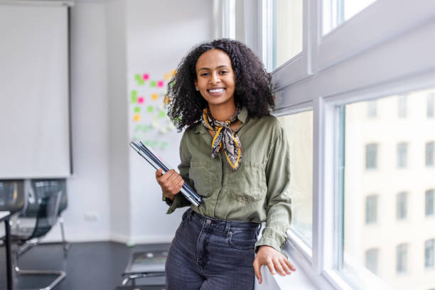 Smiling portrait of a beautiful woman standing in office.