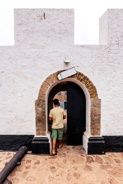 Ghana, Central, man walking through the entrance at Fort Good Hope, a former Dutch slave fort on the Atlantic Ocean