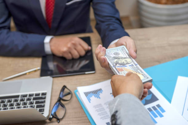 Close-up Of Businessperson Taking money from another person- funding for your business in Ghana