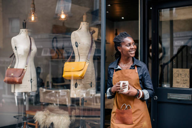 A female entrepreneur stands outside her store. Doing business in Ghana