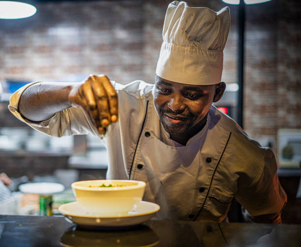 Black male chef garnishing food in kitchen. Businesses to start in Ghana